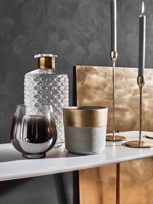 Gebürstes Metall Deko Graue Vase mit Bordüre aus gebürstetem goldenen Metall neben Glasvasen und goldenem Kerzenständer