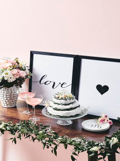Regali di nozze originali Bellissima decorazione nuziale con torta e spumante su uno scaffale davanti ad una parete rosa