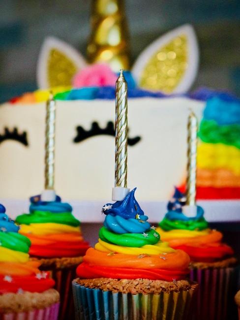 Kindergeburtstag Rainbow Cupcakes vor einer Einhorntorte