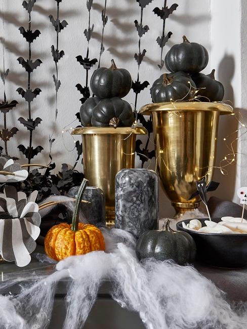 decorazioni halloween Calici dorati vicino a piccola zucca arancione