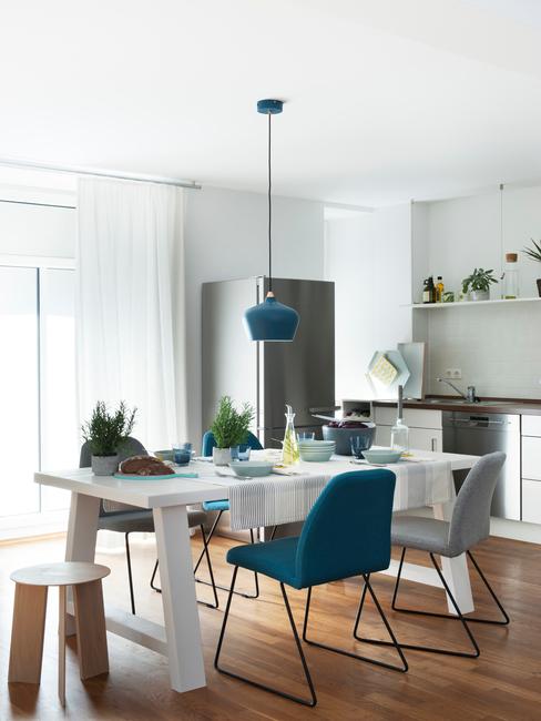idee per ristrutturare casa spendendo poco cucina open space con tavolo bianco e sedie colorate