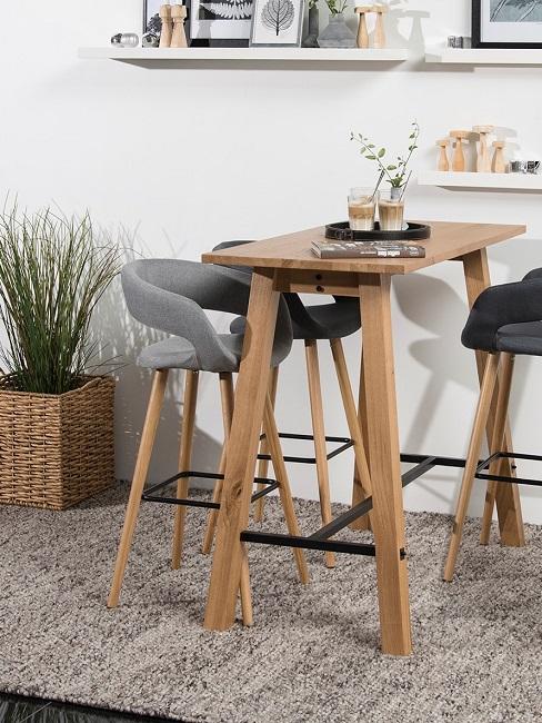 Ein Bartisch aus Holz mit Barhockern steht im Wohnzimmer.