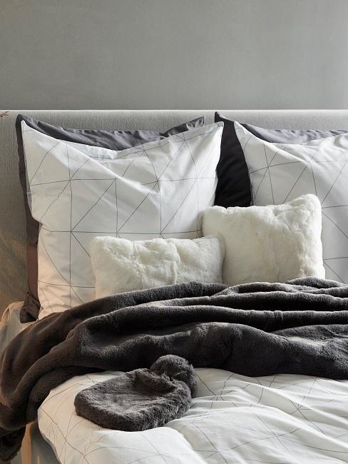 Geometrische Muster Ein Bett im Schlafzimmer mit geometrischer Bettwäsche.