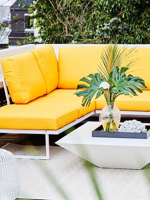 Terrasse mit einer Loungeecke mit gelben Polstern.