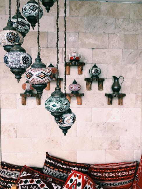decoracion-etnica Pared con jarrones colgados del techo con motivos decorativos étnicos