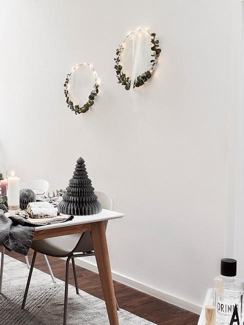 Zwei Metallringe in Gold mit Eukalyptus hängen an der Wand im Esszimmer.