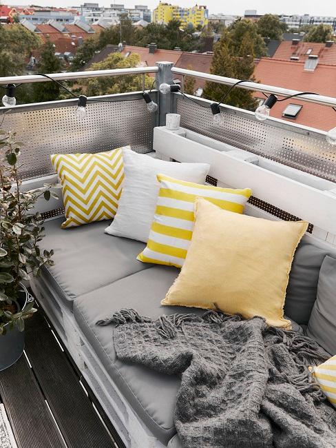 Kleiner Balkon: Sofa aus weiÃen Paletten mit gelben Kissen dekoriert