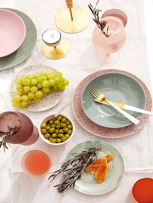 Bunt gedeckter Tisch mit Trauben und Oliven
