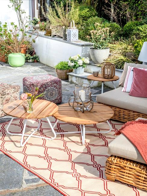 Terrasse dekorieren Teppich Sitzecke Tische Poufs