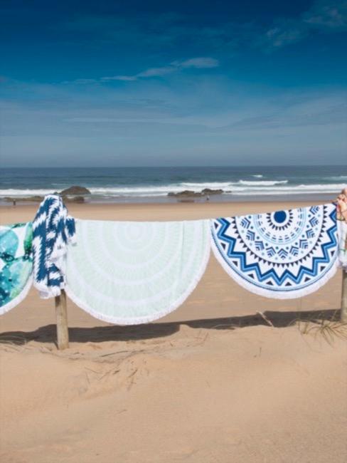 Koce plażowe z motywem batiku, zawieszone na palach na plaży