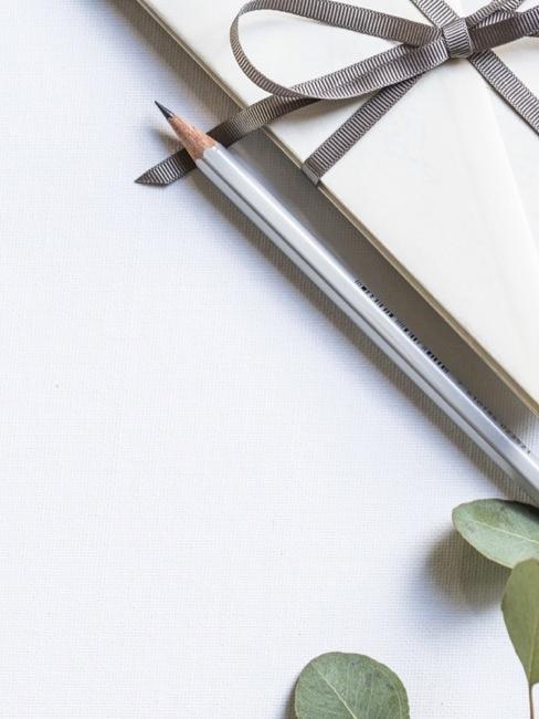 Cartes de remerciement de mariage Enveloppe beige avec ruban gris, crayon pointu et feuilles d'eucalyptus sur fond clair