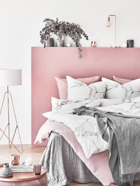 Dormitorio rosa con mantas grises y rosas