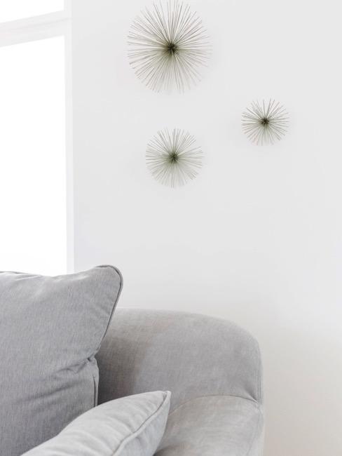 Pared blanca con estrellas plateadas decorativas y sofá gris minimalista