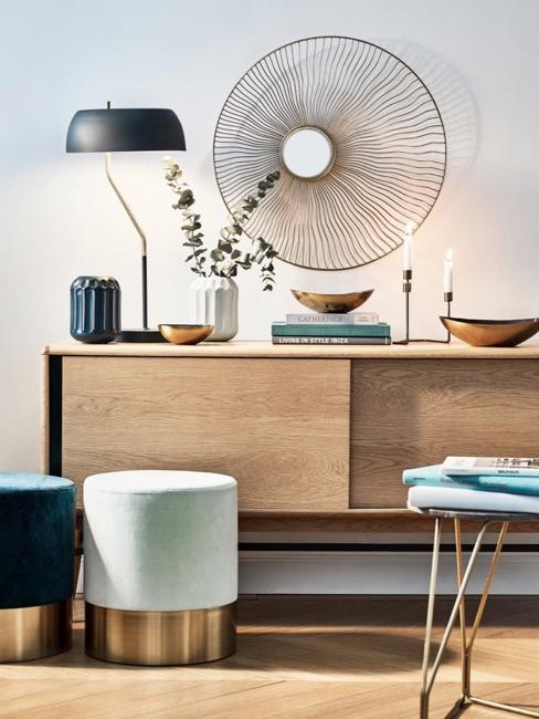 Sideboard mit verschiedener Dekoration wie Wandobjekt in gold