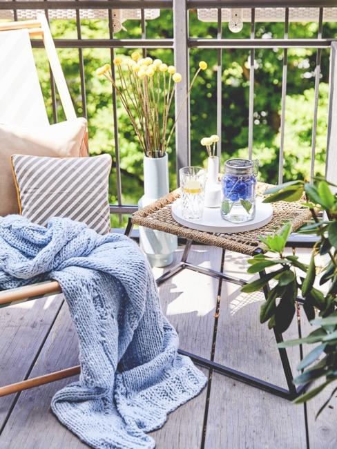 Meubles de balcon clairs avec plaid en tricot bleu clair