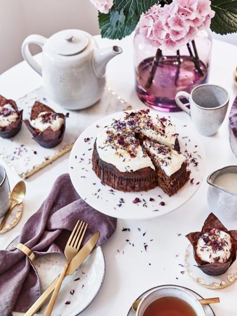 Table dressée blanc et lilas avec gâteau au chocolat à la crème