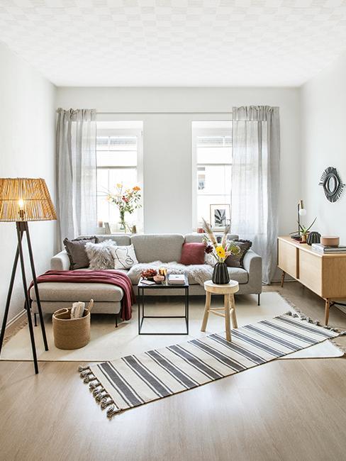 Dywan do salonu Salon z szarą kanpą oraz brązowymi tekstyliami dekoracyjnymi