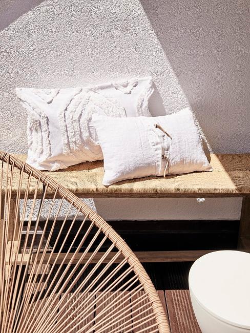 Kissen im mexikanischen Stil auf einer Holzbank auf einer Terrasse