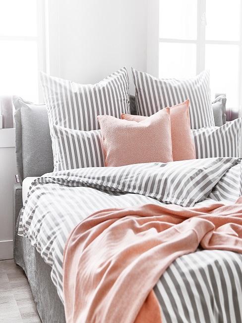 Bett mit grauer Bettwäsche im Schlafbereich