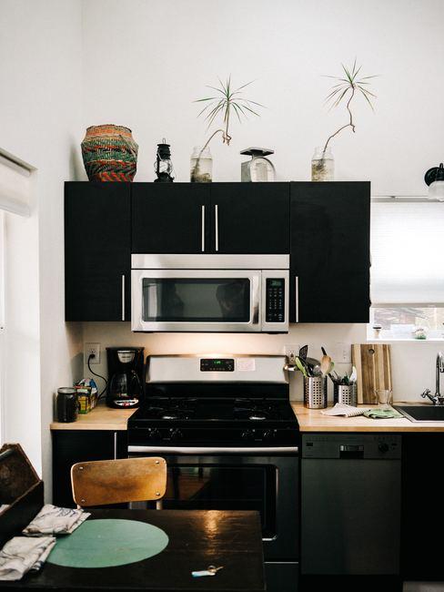trucos-limpiar-el-horno Cocina pequeña en tonos negros y blancos con horno de fondo