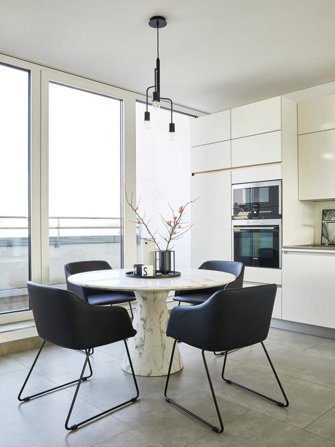 entretien-fauteuil-cuir Salon de style moderne avec une table ronde autour de laquelle se trouvent 4 fauteuils en cuir bleu foncé