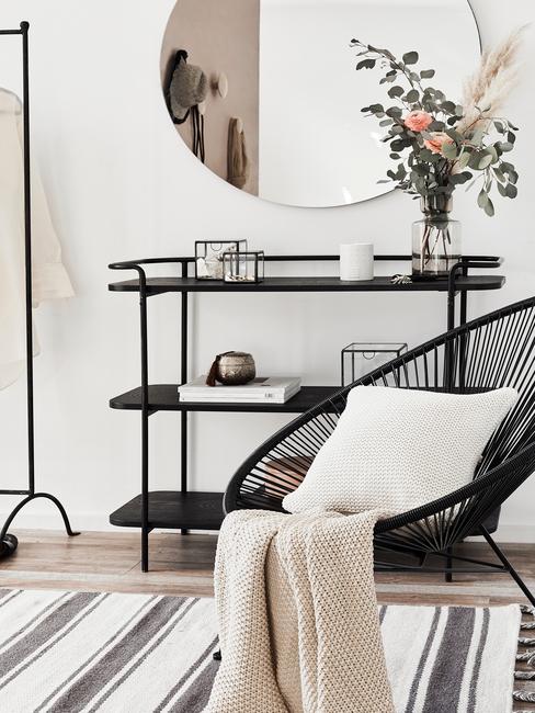 Salon avec grand miroir rond au dessus d'une étagère noire