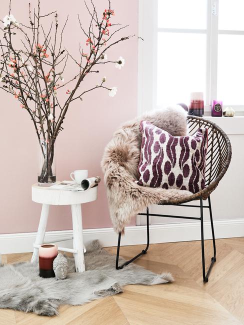 coin-lecture Coin lecture avec fauteuil, tabouret blanc à 3 pattes et mur peint en rose