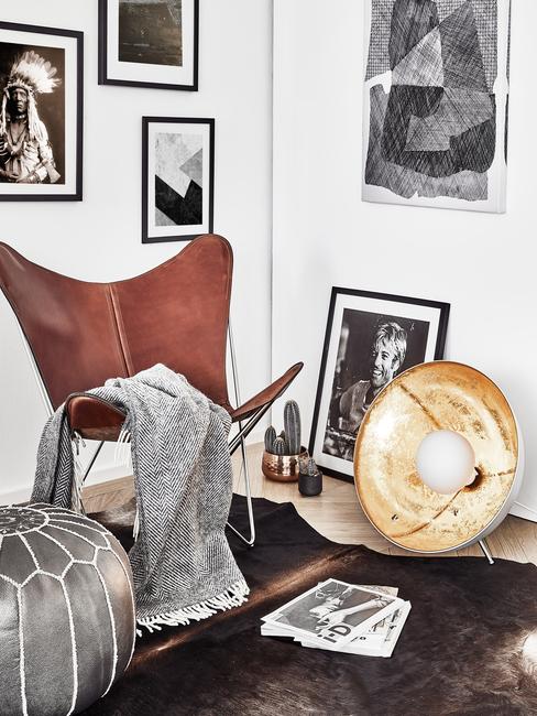 deco-cuir Coin salon avec fauteuil et pouf en cuir ainsi que des photos encadrées sur des murs derrière