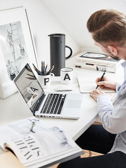 vision-board Homme au bureau avec un ordinateur portable et un vision board derrière