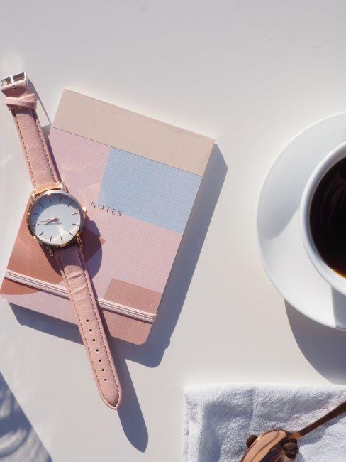 tecnica del pomodoro quaderno e orologio rosa vicino a tazza di caffè