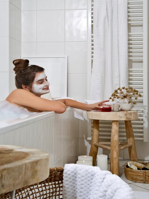 Domowe spa Dziewczyna relaksująca się w wannie, z maseczką na twarzy