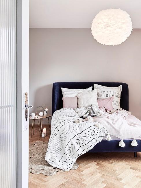 camera da letto con letto blu e lampadario a soffitto rotondo