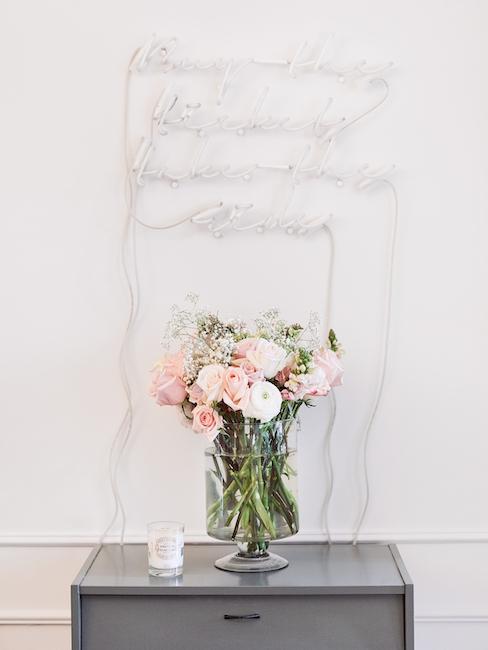 Leuchtschrift Beistelltisch mit Blumen in Vase und Leuchtschrift darüber
