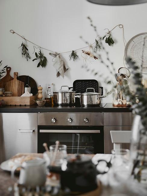 Backofen hCucina moderna con forno in acciaiointer einem gedeckten Esstisch, darauf und daneben Küchenutensilien