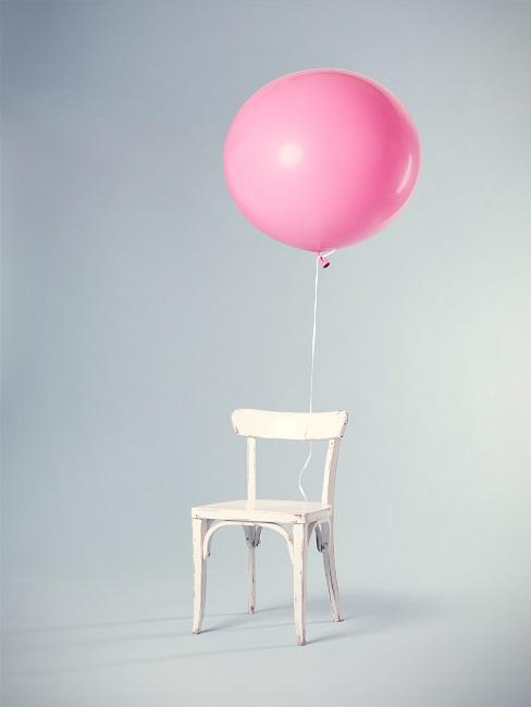Junggesellenabschied Weißer Stuhl mit rosafarbenem Ballon in leerem Raum