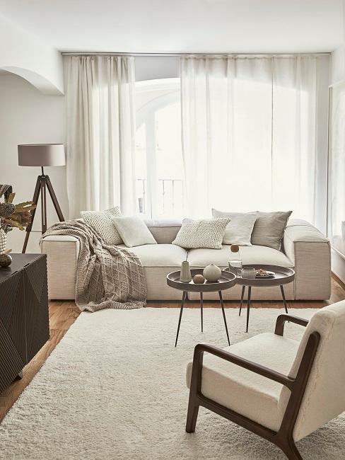 Jasny salon z dużą kanapą i fotelem