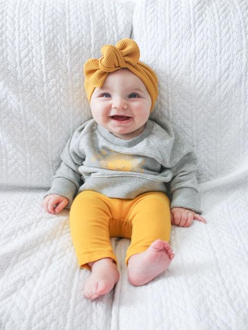 Pucken Baby auf einem Sofa, lachend