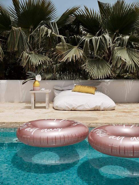 Luftmatratze Zwei rosafarbene Schwimmringe in einem Pool