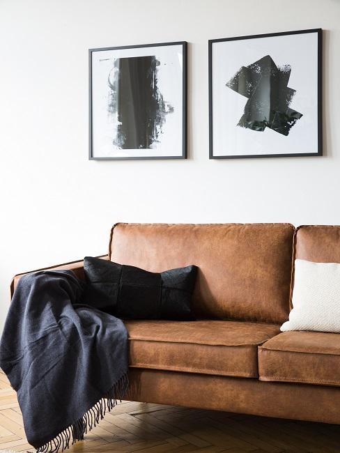 Braunes Ledersofa mit einer Decke und Kissen
