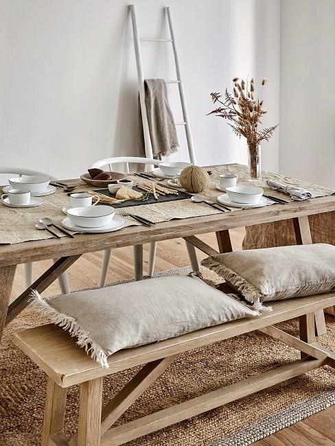 Esszimmr skandinavisch mit Holztisch, Holzbank und beigen Kissen