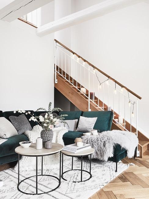 Treppenhaus gestalten mit Lichterkette neben grünem Sofa und Couchtisch