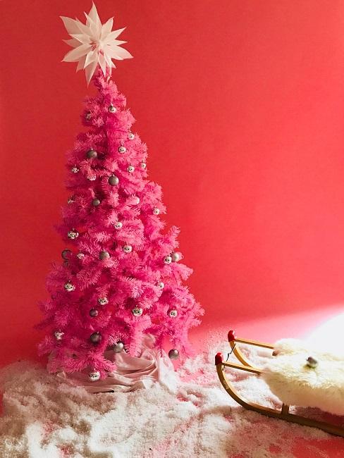 Pinker Weihnachtsbaum im Kunstschnee und Deko-Schlitten