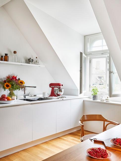 Helle weiße Küche mit Holztisch und einigen Dekoelementen