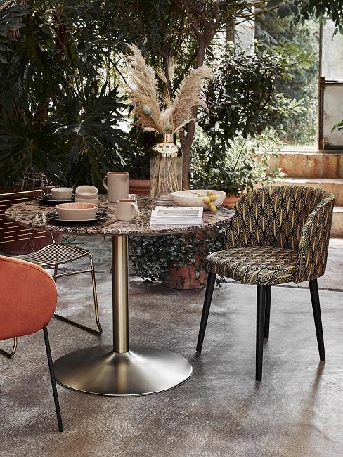 Modernes Esszimmer draußen mit tropischen Pflanzen