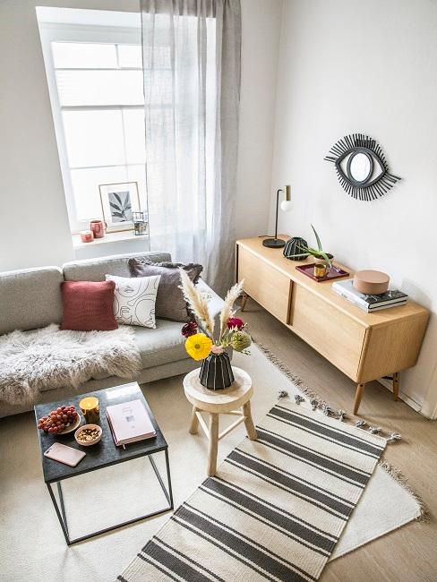 Wohnraum von oben mit einer Couch, einem Couchisch und einem Sideboard aus hellem Holz.
