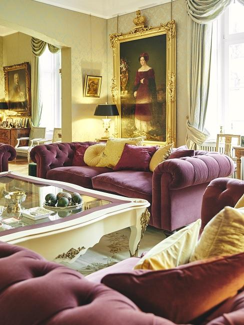 luxus möbel Barockes, luxuriöses Wohnzimmer mit dunkelroter Polstergarnitur und opulenter Deko