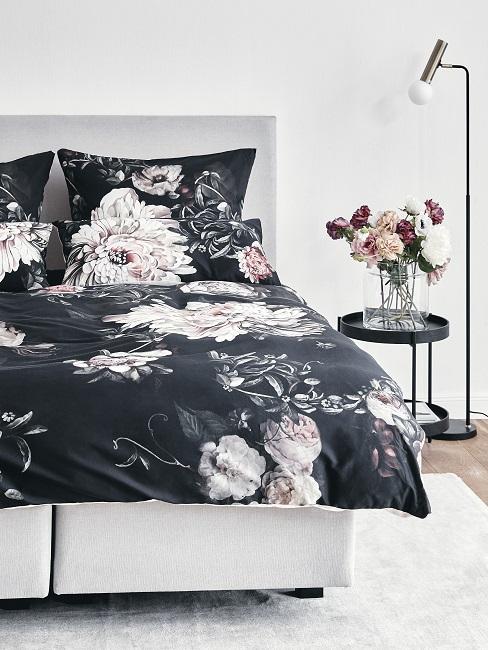 Schlafzimmer mit Bett mit geblümter Bettwäsche