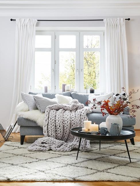 Sofa im Wohnzimmer mit Kissen und Strick-Plaid