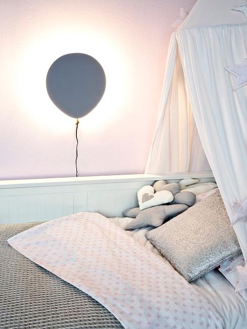 Ballon als Wandlampe neben einem Kinderbett