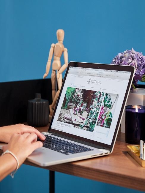 Laptop an einem Schreibtisch vor blauem Hintergrund